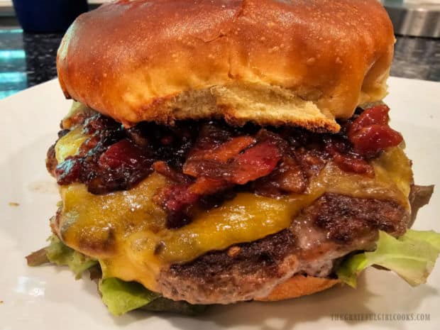 A cooked cheeseburger patty, topped with Bacon Jam For Burgers.