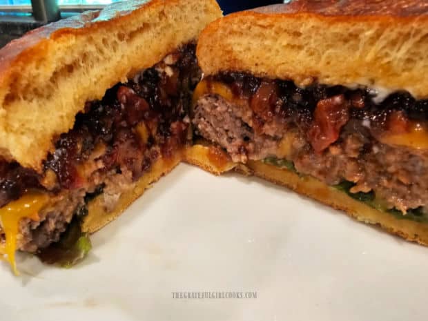 Cheeseburger is sliced in half, showing the Bacon Jam inside.