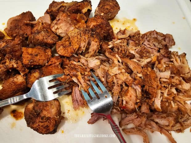 Two forks are used to shred the very tender, seasoned pork carnitas.