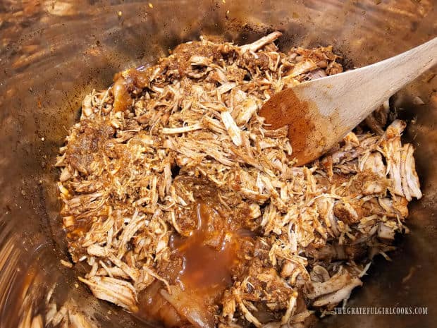 Shredded pork is added back into the sauce in the Instant Pot.