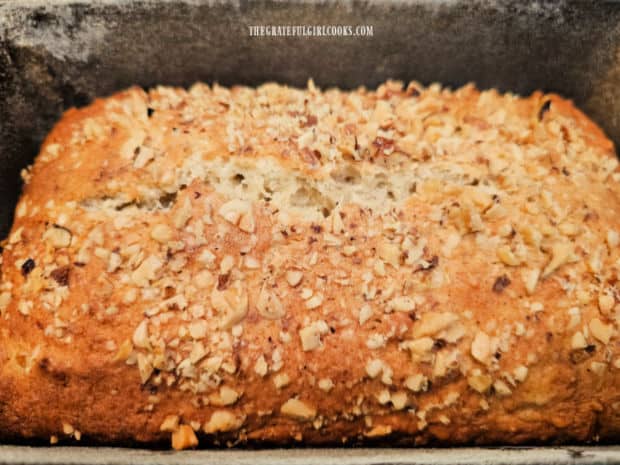 A loaf of pineapple walnut bread, in the pan after baking.