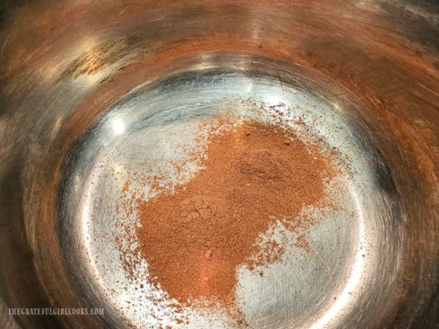 Pumpkin spice mix is heated on low in a medium saucepan.