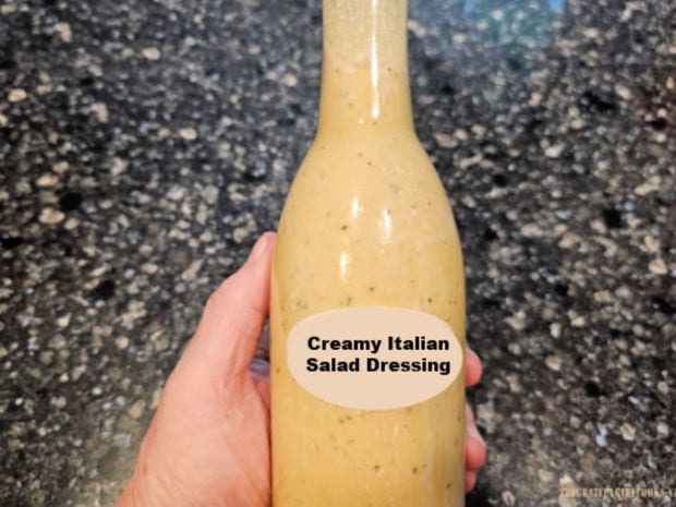 When fully mixed, salad dressing is poured into a bottle.