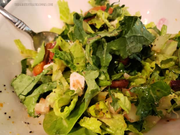 After refrigeration, creamy Italian salad dressing is drizzled on green salad.