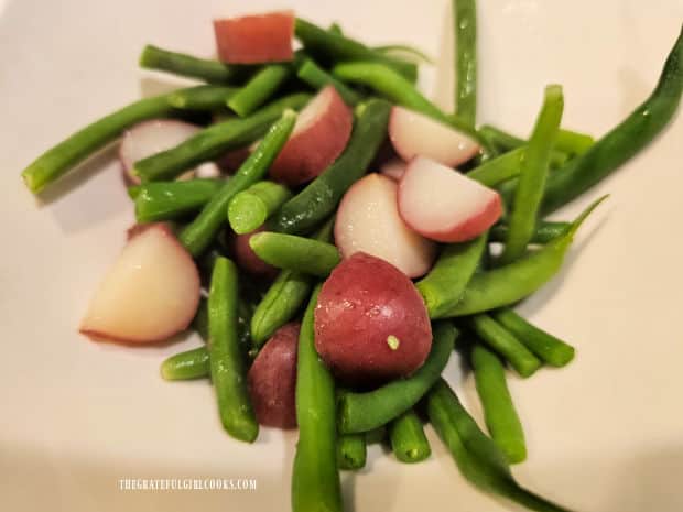 The hot cooked veggies are transferred to a small serving bowl.