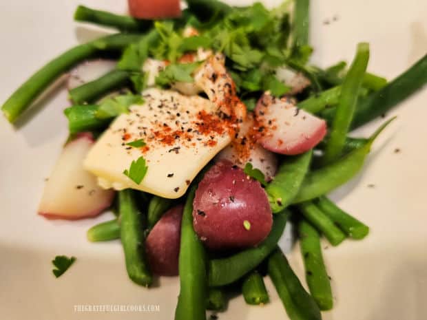 Butter, parsley and spices are added to the green beans and red potatoes.