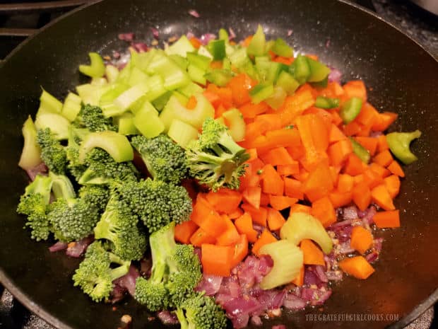 Broccoli, carrots, green bell pepper and celery are added to the skillet.