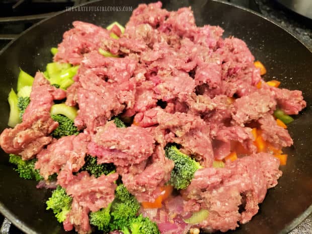 One pound of ground beef is added to the veggies in the skillet.