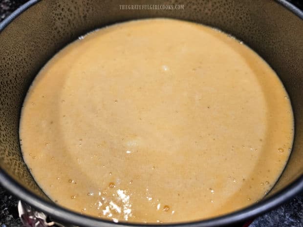 Cornbread batter is poured into a greased springform pan.