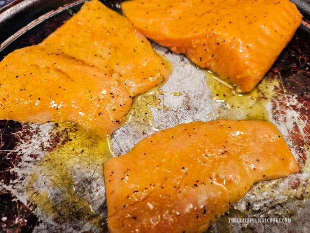 Lemon sauce is generously brushed over the top of the salmon pieces.