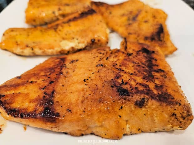 A plate of simple lemon pepper salmon, cooked and ready to be eaten.