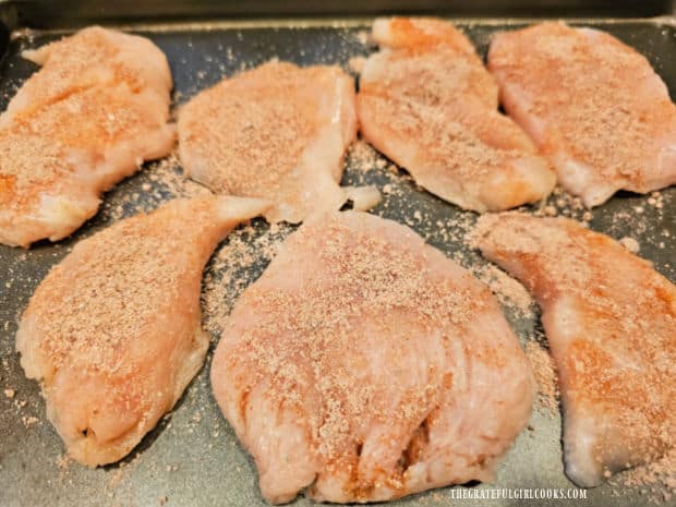 Spice mixture is sprinkled over each chicken breast piece, then drizzled with oil.