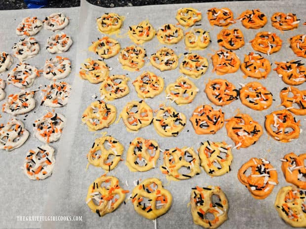 Chocolate dipped Fall pretzels drying on parchment paper.