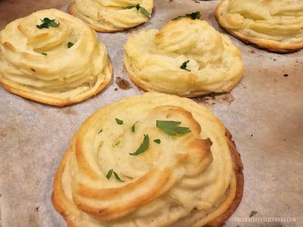 Fresh parsley is sprinkled on golden brown Duchess potatoes after baking.