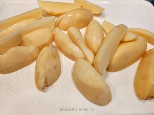 Russet potatoes are cut into quarters after peeling them.