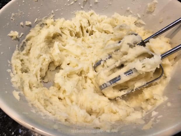 Electric mixer or potato masher is used to mash potatoes.