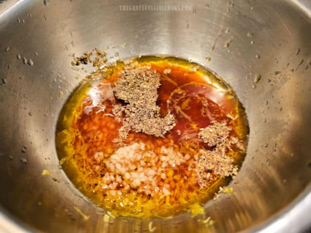 Oil, vinegar, soy sauce, lemon juice, zest and spices for marinade in a bowl.