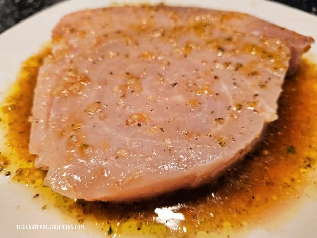 Swordfish is covered with the lemon herb marinade before cooking.