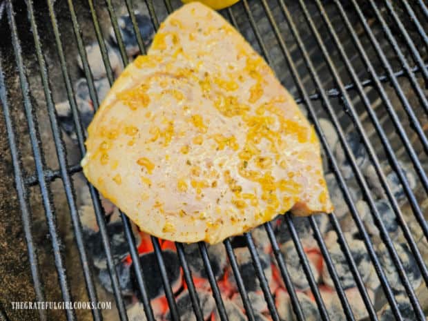 The marinated swordfish cooks on a hot BBQ grill before turning it over.