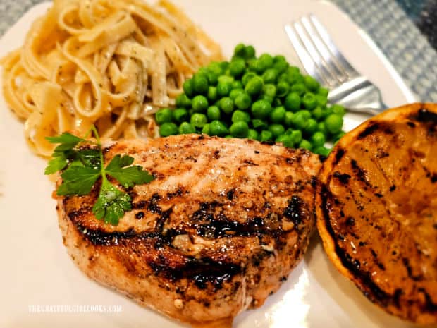 Grilled Lemon Herb Swordfish on a plate with pasta, peas and grilled lemon.