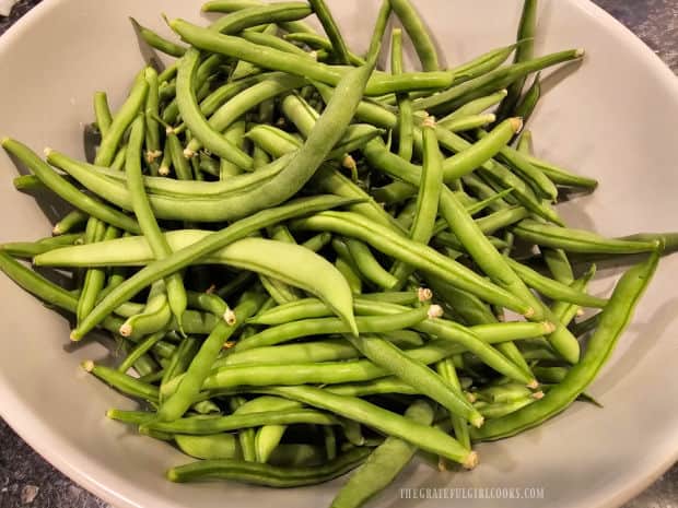 A bowl of fresh green beans before the ends are trimmed.