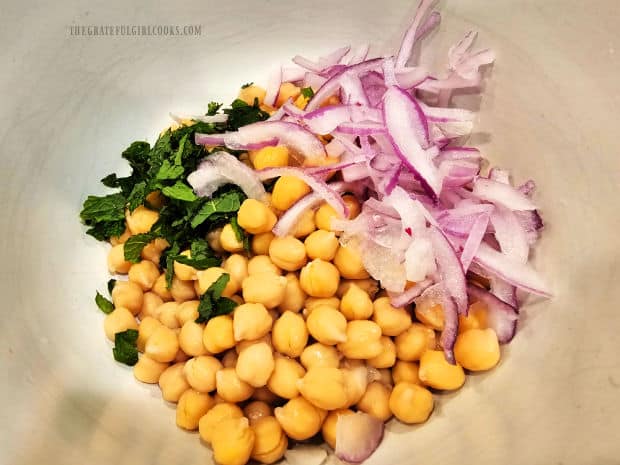 Sliced red onion and chopped fresh mint are added to the chickpeas.