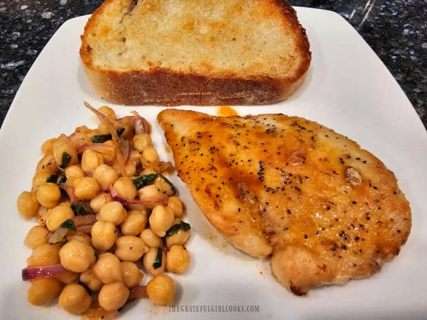 Mediterranean chickpea salad, served with roasted chicken and garlic bread.