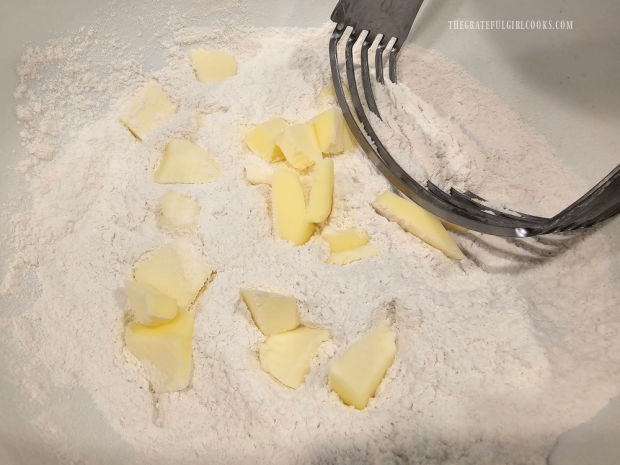 Chunks of very cold butter are cut into the flour mixture with a pastry cutter.