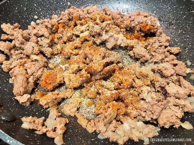 After grease is drained, spices are added to the ground beef mixture.