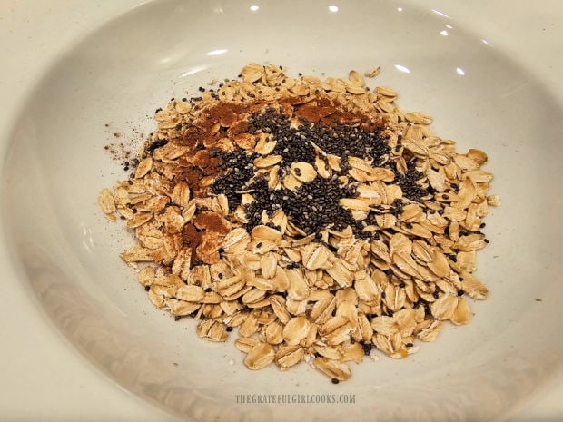 Old-fashioned oat, chia seeds and cinnamon in a white bowl.