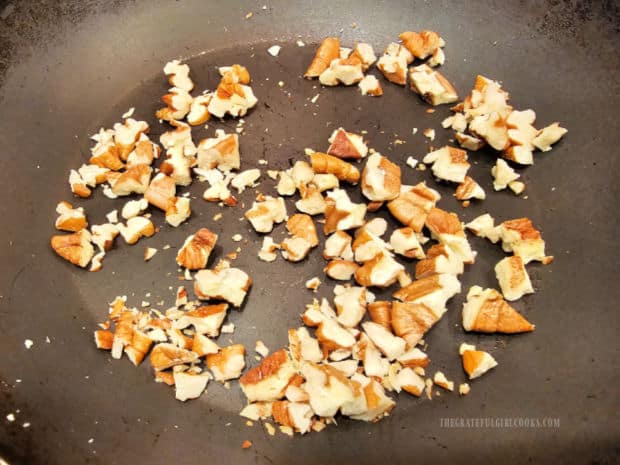 Chopped pecans are lightly toasted in a dry skillet.