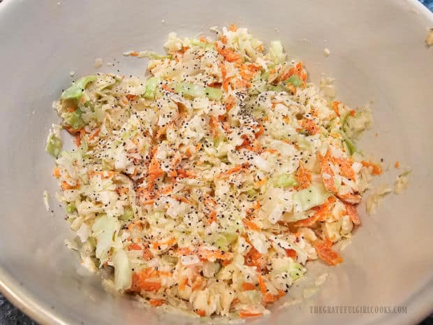 Classic creamy coleslaw is combined, refrigerated, and topped with additional poppy seeds to serve.