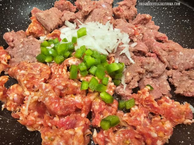 Ground beef, Italian sausage, onions and bell pepper cook in a large skillet.