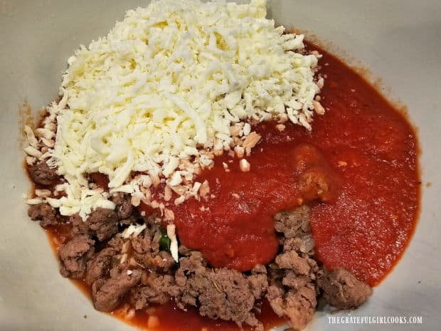 Shredded mozzarella cheese and marinara sauce in a bowl with the meat mixture.