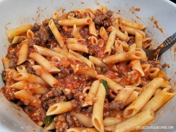 Meat filling is stirred to fully combine it with the cooked pasta.