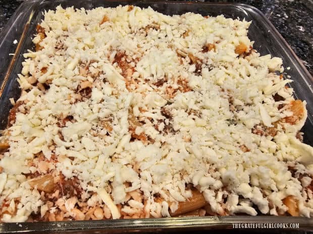 Additional grated mozzarella cheese is sprinkled on top of the casserole before baking.