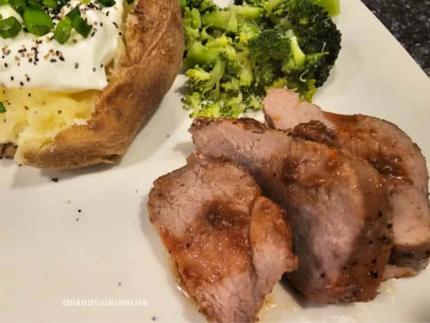 Slices of maple orange pork tenderloin, served with broccoli and baked potato on the side.