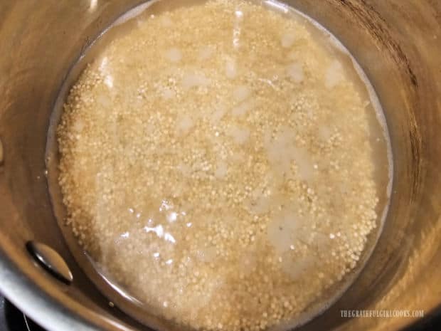 Quinoa is cooked in boiling water in a saucepan.