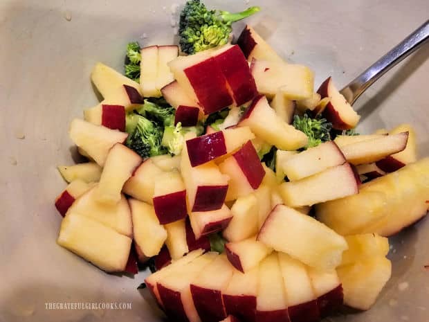 Chopped apple (with lemon juice) and chopped broccoli in a medium bowl.