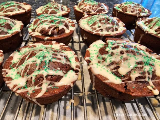 Green decorative sugar is sprinkled on top of the icing-drizzled muffins.