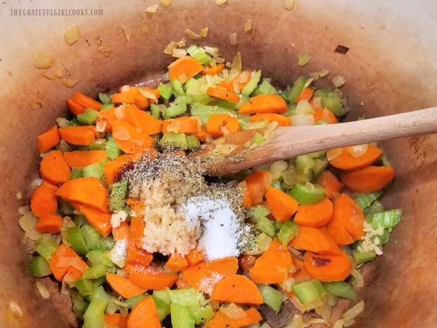 Minced garlic, salt, pepper and Italian seasoning are added to cooked vegetables in pot.