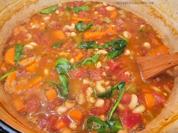 The heat of the soup wilts the baby spinach leaves.