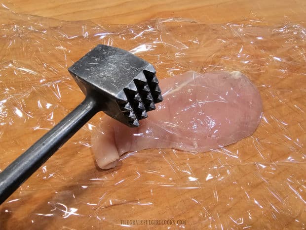 Boneless skinless chicken breasts are pounded thin, using the flat side of a meat mallet.