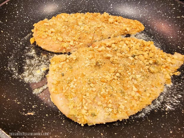 The honey Dijon chicken breasts are cooked in melted butter in a large skillet.